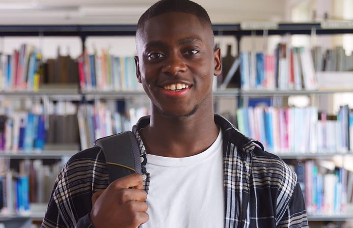 Young man standing in library